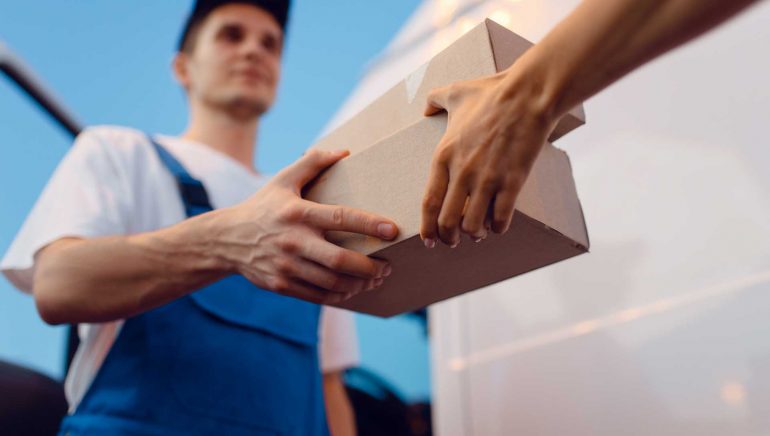 deliveryman-gives-parcel-to-female-recipient-HH3Z3T7.jpg